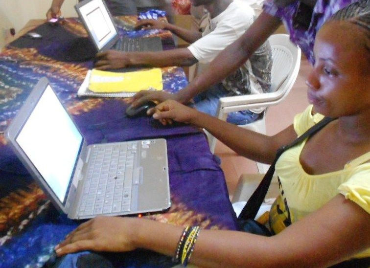 Young women working at laptops during computer training