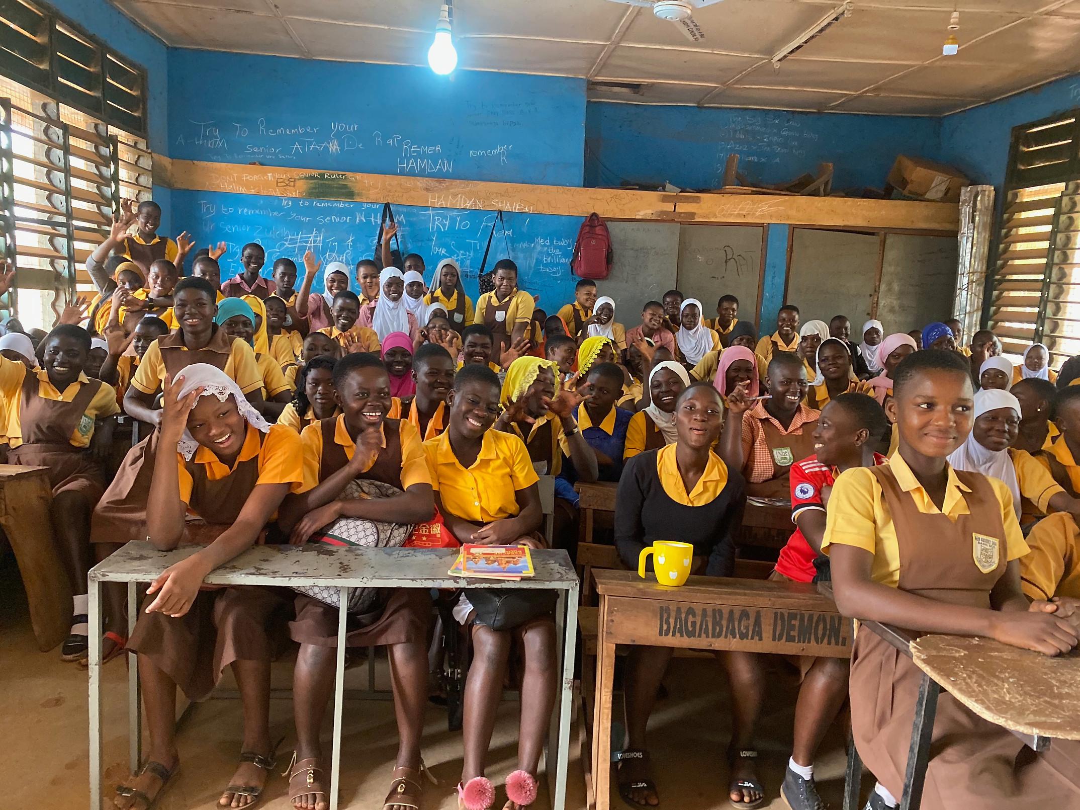 Students seated at wooden desks in a classroom