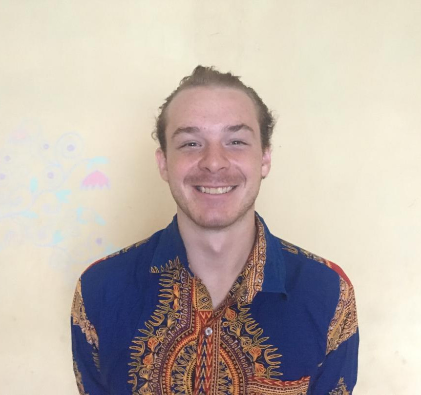 Ian Thomas seated and smiling in a patterned shirt